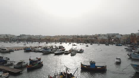 Aerial-Push-In-Shot-Of-The-Fishing-Vessels-Docked-In-Marsaxlokk-Malta