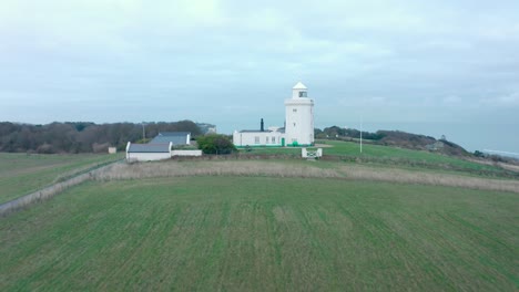 Dolly-back-aerial-drone-shot-of-south-foreland-lighthouse-to-white-cliffs-of-Dover