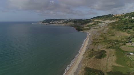 Aerial-on-the-edge-of-Charmouth-tracking-forwards-along-the-coast-towards-Lyme-Regis