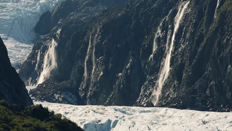 Ice-Melting-Waterfalls-From-Cliffs-Above-Glacier-Mouth-in-Wilderness-of-Alaska,-Cinematic-Slow-Motion-Full-Frame-Shot