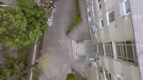 Direct-Overhead-Aerial-Drone-Shot-of-an-Alley-Way-with-a-Sketchy-Male-Walking-Around-Behind-a-Fence