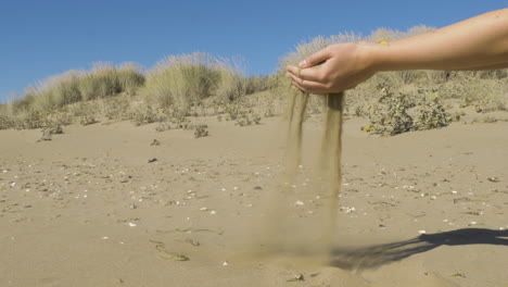 Nehmen-Sie-Sand-Vom-Strand-Und-Lassen-Sie-Ihn-Durch-Die-Finger-Zurück-Zum-Strand-Gleiten