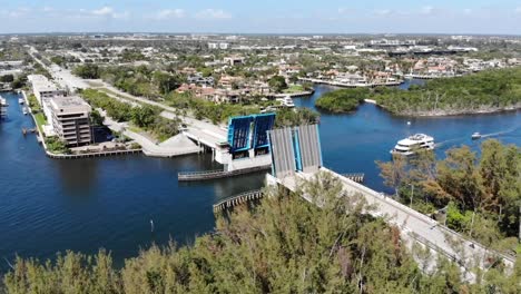 Aerial-shot-moving-along-a-bridge-that-has-opened-to-let-a-large-Yacht-pass-through