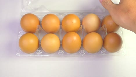 Man-takes-eggs-from-container-on-white-background