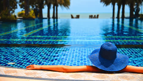 Woman-wear-hat-in-swimming-pool-resort-hotel