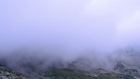 Wide-shot-of-aerial-drone-view-of-Retezat-Mountains,-Romania-seen-through-fog