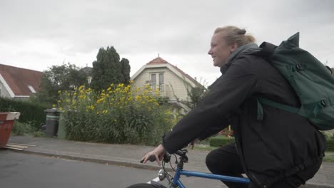 Joven-Holandesa-En-Bicicleta-A-Casa,-Con-Una-Sonrisa-En-La-Cara