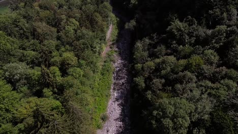 Aerial-flight-over-a-stream-between-the-forest