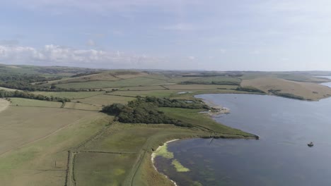 Aerial-tracking-from-right-to-left-above-the-fleet-lagoon-at-Abbotsbury,-near-Chesil-Beach