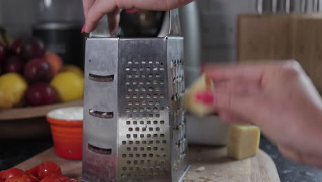 Woman-grating-cheese-on-wooden-chopping-board
