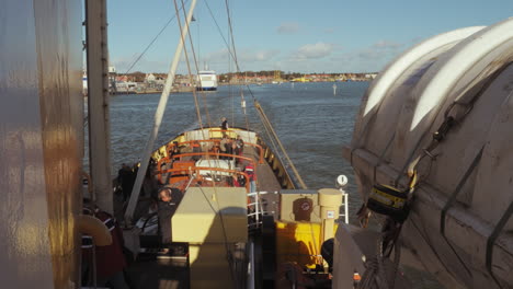 Leaving-Terschelling-island-Netherlands-harbor-for-a-day-trip-at-sea,-timelapse-ZOOM-OUT