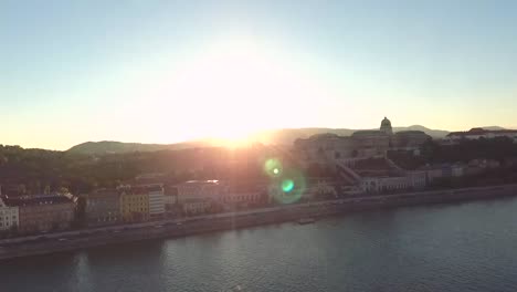 Sunset-over-the-castle-side-of-Buda,-shot-from-a-drone-hoovering-over-the-Danube-river