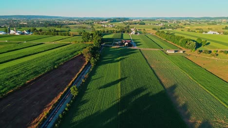 Steam-Train-Passing-through-Amish-Farm-Lands-and-Countryside-on-a-Sunny-Summer-Day-as-seen-by-drone