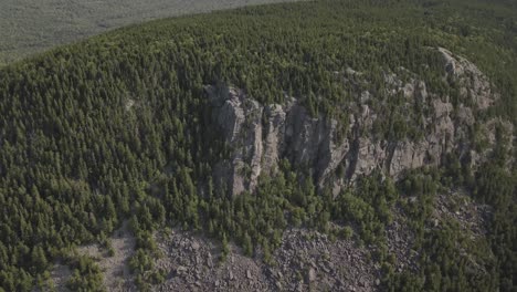 Aerial-Drone-Shot-Flying-By-Rocky-Cliff-On-Mountain-Side