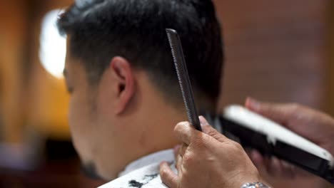 Barber-trims-the-hairs-on-the-back-of-a-customer's-head