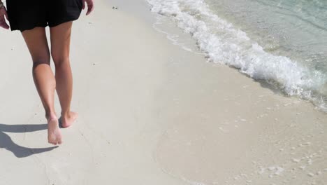 Ultra-slow-motion-shot-of-legs-and-feet-walking-on-sandy-beach-in-Thailand