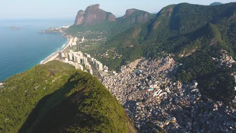 Toma-Aérea-De-Un-Dron-Siguiendo-La-Cresta-De-Una-Montaña-Que-Revela-El-Océano-Y-Los-Condominios-En-Río-De-Janeiro,-Brasil