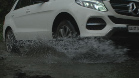 CAR-DRIVING-THROUGH-STREAM-with-splashes-,-close-up