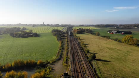 Aerial-view-of-train-just-leaving-station-going-away-through-a-bend