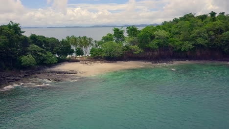 Drone-taking-flight,-revealing-a-beautiful-tropical-view-over-sea-of-Boca-Chica,-Panama
