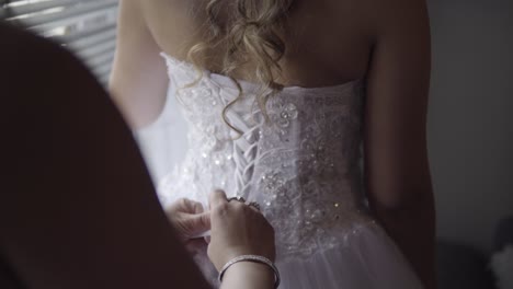 Helping-bride-to-tie-her-dress