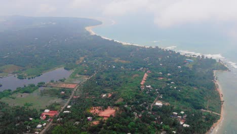 Aerial,-drone-shot-over-a-paradise-coast,-zoom-in-above-Trincomalee-city,-on-a-cloudy-day,-in-Gokanna,-in-the-Eastern-Province-of-Sri-Lanka