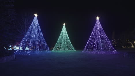 Tres-árboles-Creados-Con-Decoraciones-De-Luces-Frías-Con-Estrellas-En-La-Parte-Superior,-Noche
