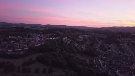 Luftaufnahme-Seitwärts-Mit-Dolly-Luftaufnahme,-Farbenprächtiger-Sonnenuntergang-über-Den-Vororten-Von-Exeter,-England