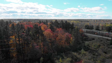 Wir-Kreisen-Um-Hohe-Wasserleitungen-Vor-Den-Toren-Von-Ottawa-(Ontario)-Und-Senken-Uns-Dann-Um-Sie-Herum,-Um-Sie-Dann-An-Einem-Sonnigen-Tag-Mit-Den-Herbstbäumen-Im-Hintergrund-Zu-Begleiten
