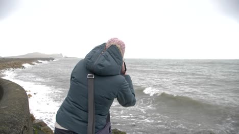 Female-photographer-taking-photos-of-rough-sea