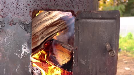 Small-wood-fire-viewed-through-the-door-in-a-barrel-cooker