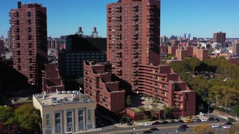 Largo-Disparo-De-Dron-De-Movimiento-Lateral-Que-Comienza-En-Edificios-De-Apartamentos-De-Gran-Altura-En-Nueva-York-Y-Se-Desplaza-Hacia-Abajo-Para-Seguir-El-Tráfico-En-La-Unidad-FDR-A-Lo-Largo-Del-Río-Harlem-En-Manhattan