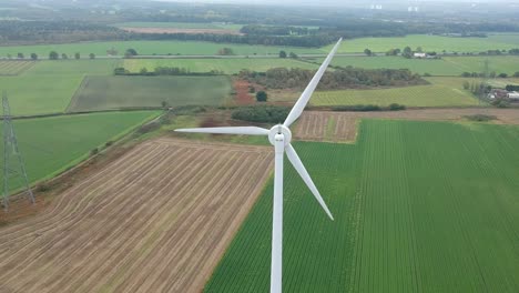Aerial-shot-moving-towards-close-up-of-wind-turbine-in-British-countryside