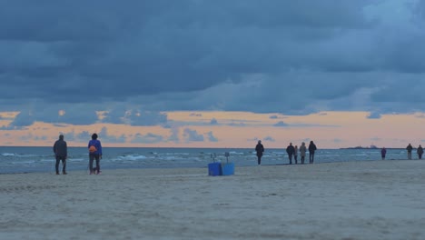 Menschen,-Die-Am-Strand-Spazieren-Gehen,-Zwei-Personen,-Die-Nordic-Walking-Machen,-Farbenfroher-Herbstsonnenuntergang,-Weitwinkelaufnahme