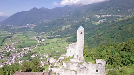 Aerial-panoramic-view-of-Borgo-Valsugana,-in-Trentino,-Italy,-with-drone-flying-around-the-Castel-Telvana
