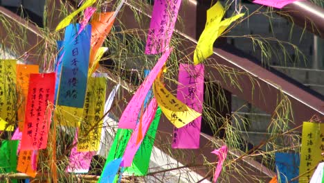 Close-up,-People-bunding-wishes-on-paper-to-a-tree-in-Zozo-ji-Temple