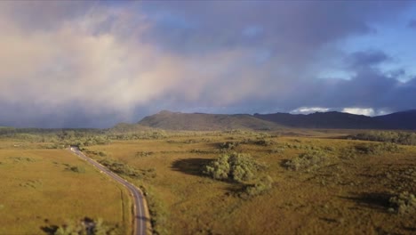 Vuelo-Aéreo-Sobre-Montañas-Nubladas-Y-Pastizales-En-Tasmania-En-Australia,-Tiro-De-Larga-Distancia-Avanzando-Y-Descendiendo