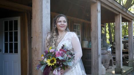 Atlanta,-GA---November-21,-2018:-A-millennial-bride-poses-wearing-her-wedding-dress-and-holding-flowers-during-golden-hour-before-her-wedding-at-a-rustic-rural-country-farm-venue