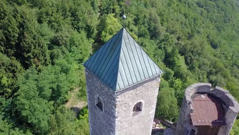 Aerial-view-of-the-Tower-of-Castel-Telvana-in-Borgo-Valsugana,-Trentino,-Italy-with-drone-flying-up-and-tilting-down-to-end-with-a-top-view-of-the-castle