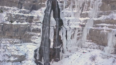Ice-climbers-climb-a-frozen-waterfall-in-extreme-conditions---zooming-in
