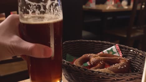 Hand-drinking-from-a-beer-and-a-bretzel-in-Germany