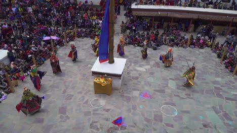 Tourists-watching-chham-dance-performed-by-masked-monks-at-Hemis-monastery-on-Hemis-festival,-shot-from-above
