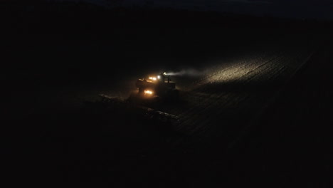 Traktor-Erntemaschine,-Die-In-Einem-Feld-Bei-Nacht-Aus-Der-Vogelperspektive-Arbeitet