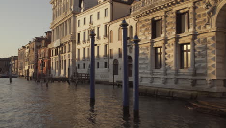 Navegando-Por-El-Canal-Grande-A-Lo-Largo-De-La-Galería-De-Arte-Con-Palines-Azules-En-Venecia,-Italia