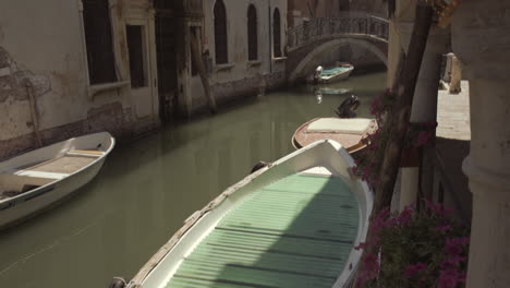 Boats-parked-in-Venice-canal-on-a-sunny-day,-Italy