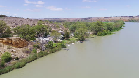 Aerial-push-in-shot-showing-a-group-of-holiday-shacks-along-the-stunning-River-Murray-in-South-Australia