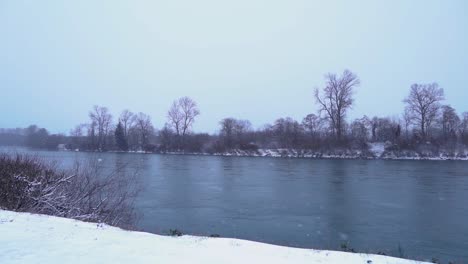Snow-falling-in-storm-by-river,-Slow-Motion,-Still-Shot