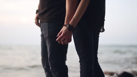 Couple-holding-hands-and-standing-by-a-beautiful-lake-in-slow-motion