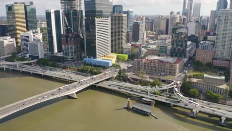 Captain-Cook-Bridge,-Brisbane-City,-and-the-Queens-Wharf-development-in-an-aerial-pan-from-the-river