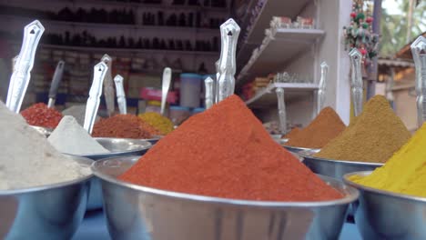 Close-up-overview-across-lots-of-vibrant-colourful-herb---spice-powders-in-outdoor-store-market-scene